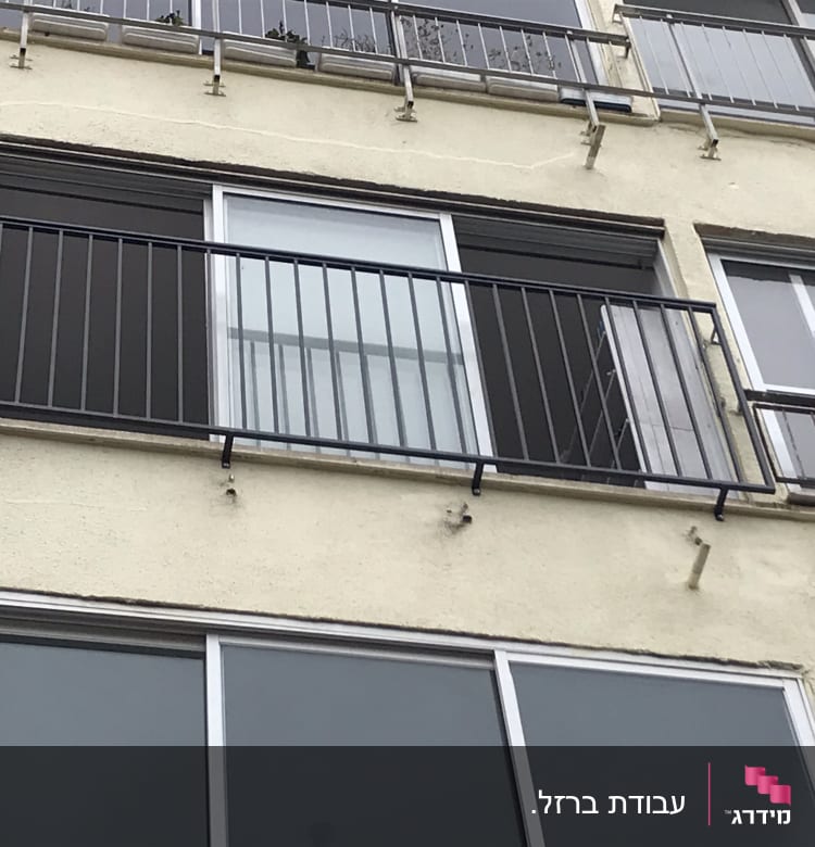 מעקה מתכת שחור על מרפסת בניין